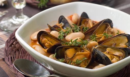 Zuppa di cozze e fagioli con erbe aromatiche.